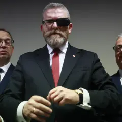 Trzech mężczyzn w garniturach. Lider z opaską na oku, zastanawia się, czy Konfederacja Korony Polskiej planuje samodzielny start w wyborach.