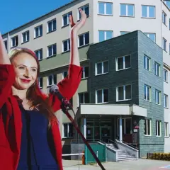 Kobieta w czerwonej marynarce przemawia przy mikrofonie na tle budynku. Czy to prawdziwe powody wściekłości "Kierownika" na projekt ustawy o reformie PIP?