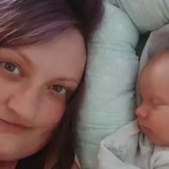 Anna Lew-Tusk, neonatolog, odpoczywa obok śpiącego noworodka.