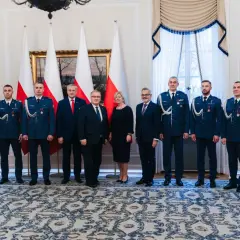 Grupa osób w mundurach i garniturach, być może związana z sekrety ochrony prezydenta i incydenty z drona pod rezydencją w marcu 2026.