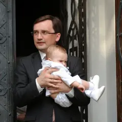 Mężczyzna w garniturze trzyma dziecko. Czy to jedno z dzieci Ziobry?
