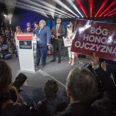Kto z polityków Konfederacji stoi za nowym projektem ustawy o dobrowolnym ZUS? Na scenie przemawia Krzysztof Bosak, a obok niego stoją inni politycy partii.