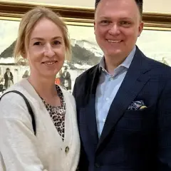 Para uśmiecha się na tle obrazu zimowego pejzażu.