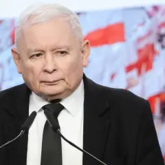 Jarosław Kaczyński w garniturze przed mikrofonami. W tle biało-czerwone flagi. Dyskusja o tym, ile Kaczyński ma emerytury, trwa.