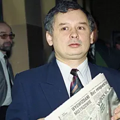 Jarosław Kaczyński z gazetą, zastanawia się, kto ze starej gwardii PiS trafił na "czarną listę". Obok mężczyzna w okularach.