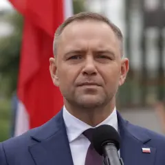 Prezydent w garniturze, obok flagi Polski, przemawia do mikrofonu. Czy prezydent może zablokować reformę renty wdowiej zaplanowaną na drugą połowę 2026 roku?