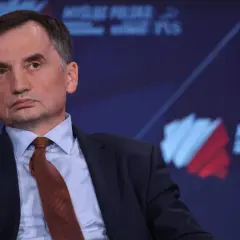 Zbigniew Ziobro w garniturze i krawacie, na tle logo "Myśl Polska".