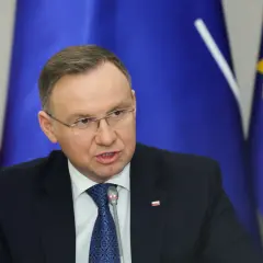 Andrzej Duda w garniturze, za nim flagi Polski i UE. Prawdziwe powody dla których Andrzej Duda zapowiedział serię wet do ustaw budżetowych.