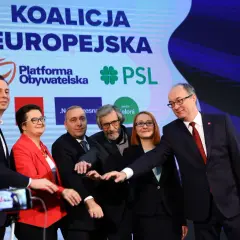 Politycy Koalicji Europejskiej na tle ekranu z logo partii i flagą UE.