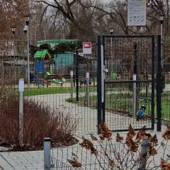 Prawda o ustawie która ma zakazać grodzenia osiedli w dużych miastach: ogrodzony plac zabaw z bramą i tablicą informacyjną.