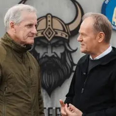 Donald Tusk i premier Norwegii rozmawiają o partnerstwie militarnym. W tle wizerunek wikinga i flagi.