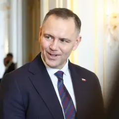 Prezydent Andrzej Duda w garniturze, z flagą Polski na klapie. Zastanawiasz się, ile zarabia prezydent Duda?