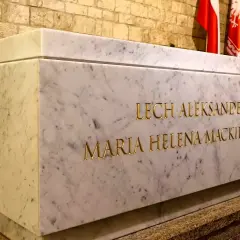 Kamienny grobowiec Lecha i Marii Kaczyńskich na Wawelu. Złote litery wyryte na marmurze.