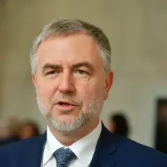 Marszałek Marek Woźniak, z siwiejącą brodą i w granatowym garniturze, mówi o tym, dlaczego marszałek Marek Woźniak unika konkursów na dyrektorów teatrów w Wielkopolsce.