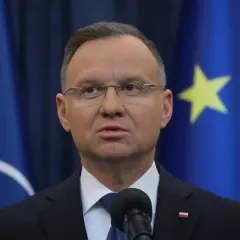 Prezydent Andrzej Duda, mimo nacisków własnej partii, odmówił ułaskawienia znanych polityków. Na zdjęciu widać go na tle flag UE i NATO.