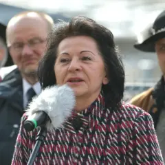 Kobieta przemawia do mikrofonu, w tle mężczyźni. Czy to ukryty majątek w nieruchomościach znanej posłanki Prawa i Sprawiedliwości?
