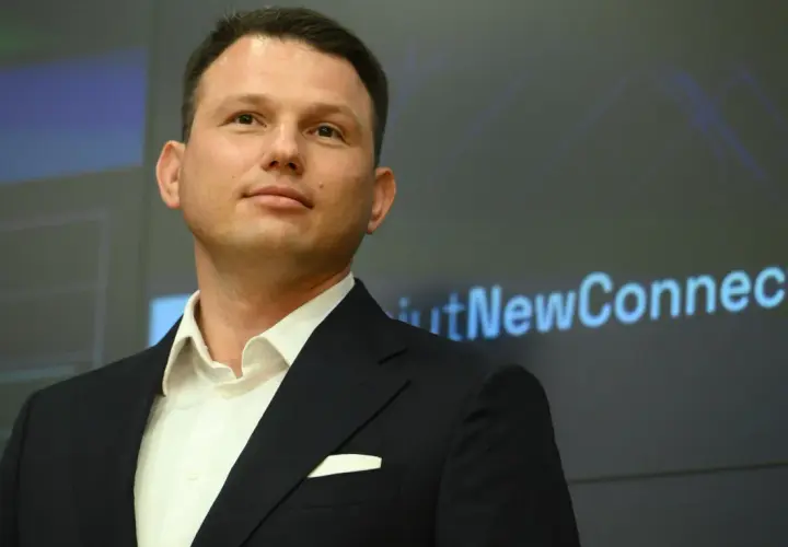 Kto finansuje luksusowe spotkania wyborcze Mentzena w największych miastach Polski? Mężczyzna w garniturze na tle ekranu z napisem "NewConnect".