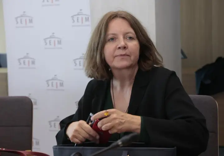 Joanna Lichocka, polityczka, siedzi przy stole. W tle logo Sejmu. Interesuje Cię, ile nieruchomości posiada Joanna Lichocka i skąd wziął się jej majątek?