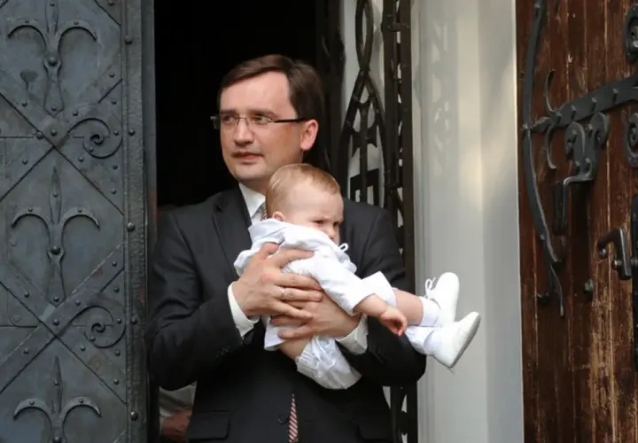 Mężczyzna w garniturze trzyma dziecko. Czy to jedno z dzieci Ziobry?