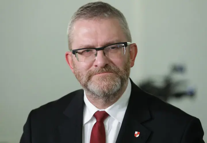 Grzegorz Braun w garniturze i krawacie, z okularami i brodą. Czy zostanie wykluczony z klubu za kontrowersyjne wypowiedzi o Izraelu?
