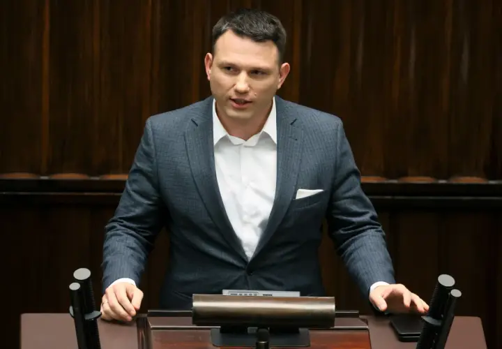 Sławomir Mentzen w garniturze przemawia, zastanawiając się, czy Sławomir Mentzen wykorzystuje AI do pisania swoich postów w kampanii prezydenckiej.