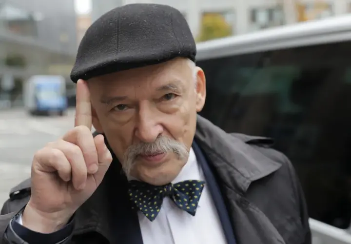 Janusz Korwin-Mikke w czapce i muszce, unoszący palec, budzi spekulacje fanów Konfederacji o jego powrocie.