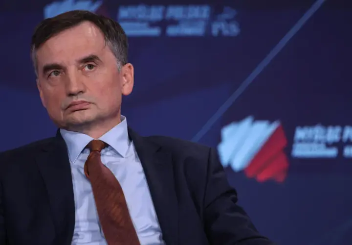 Zbigniew Ziobro w garniturze i krawacie, na tle logo "Myśl Polska".