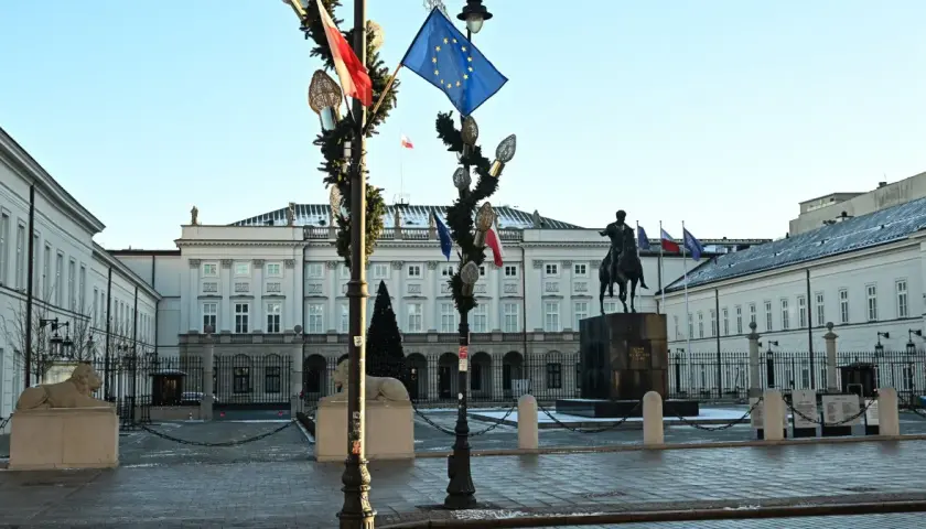 Pałac Prezydencki w Warszawie z pomnikiem konnym i flagami.