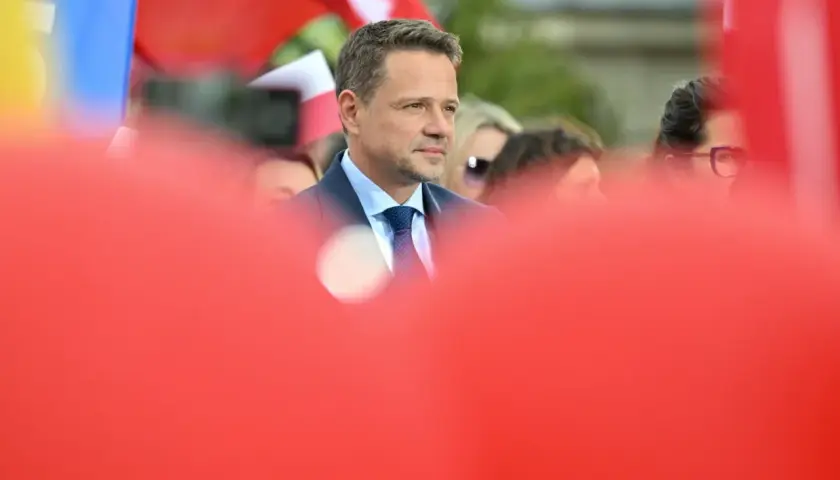 Kto stoi za nowym wizerunkiem kandydata KO na prezydenta i ile to kosztowało? Mężczyzna w garniturze na tle flag.