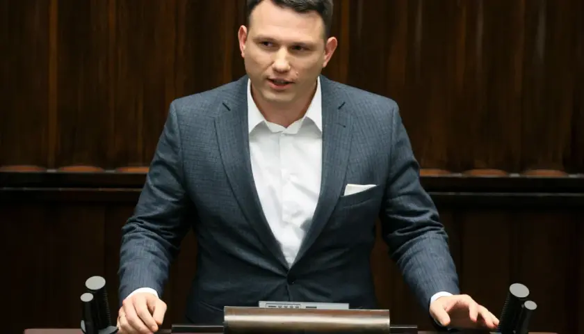 Sławomir Mentzen w garniturze przemawia, zastanawiając się, czy Sławomir Mentzen wykorzystuje AI do pisania swoich postów w kampanii prezydenckiej.