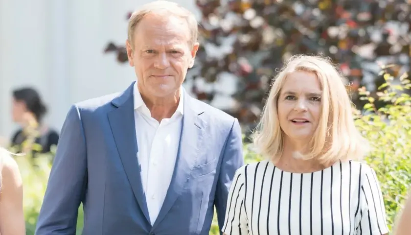Donald Tusk z żoną, Małgorzatą. Stoją obok siebie, uśmiechają się do obiektywu.