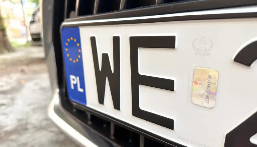 Zbliżenie na polską tablicę rejestracyjną. Kierowcy zastanawiają się, dlaczego rząd planuje trzykrotne podwyżki opłat dla kierowców w 2026 roku.