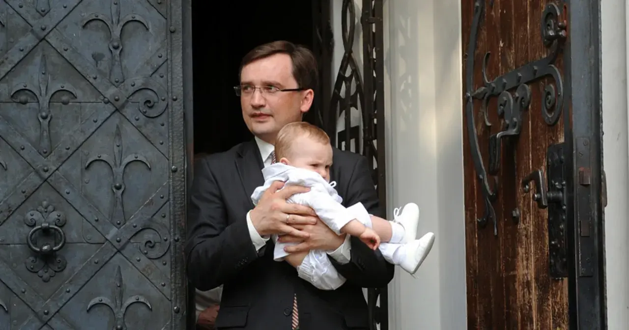 Mężczyzna w garniturze trzyma dziecko. Czy to jedno z dzieci Ziobry?