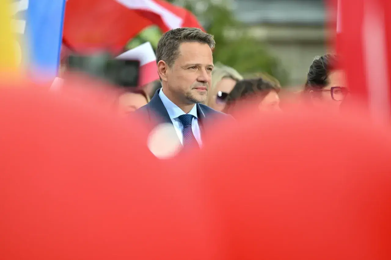 Kto stoi za nowym wizerunkiem kandydata KO na prezydenta i ile to kosztowało? Mężczyzna w garniturze na tle flag.