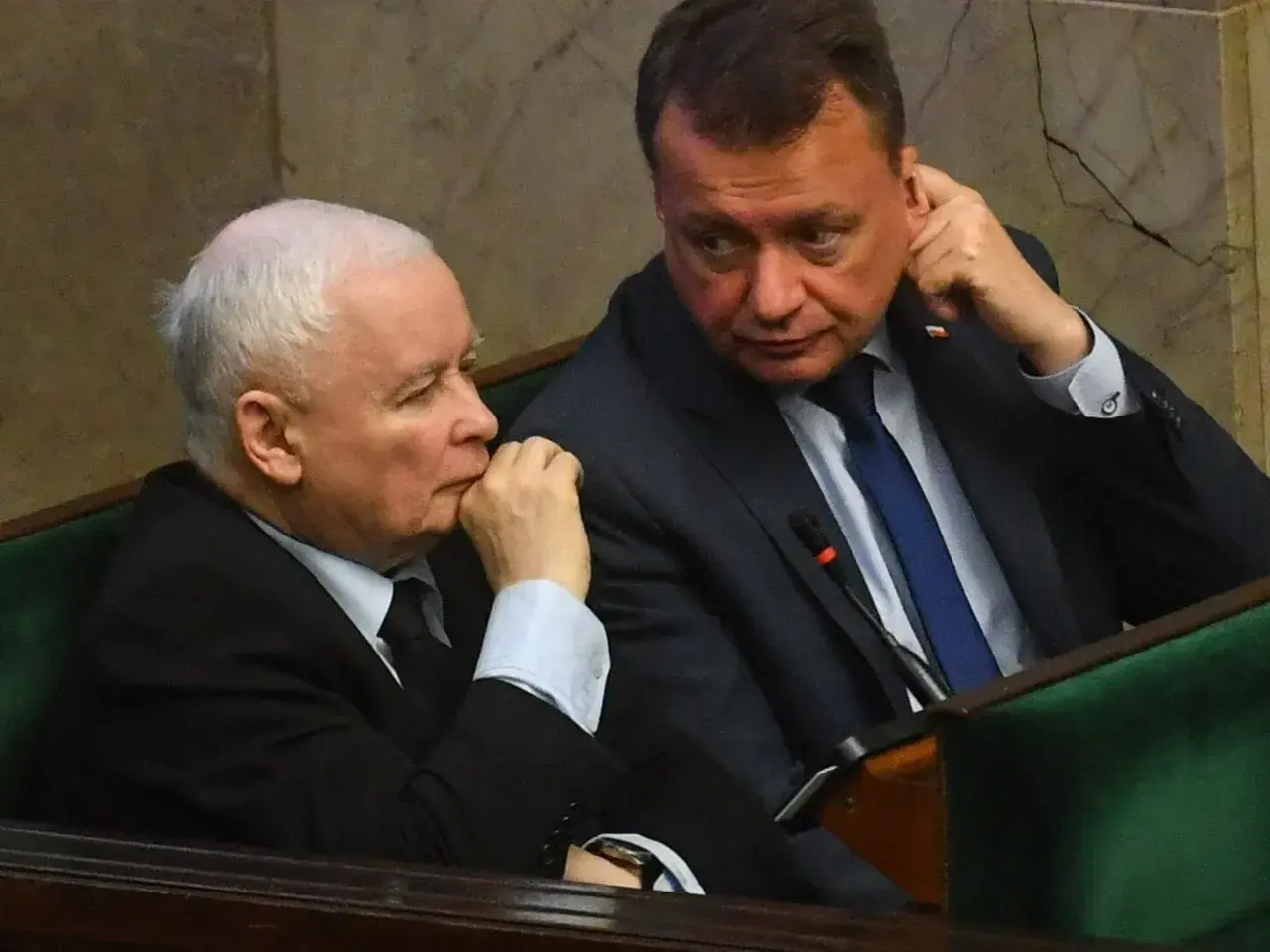 Jarosław Kaczyński i Mariusz Błaszczak siedzą obok siebie w ławach sejmowych.