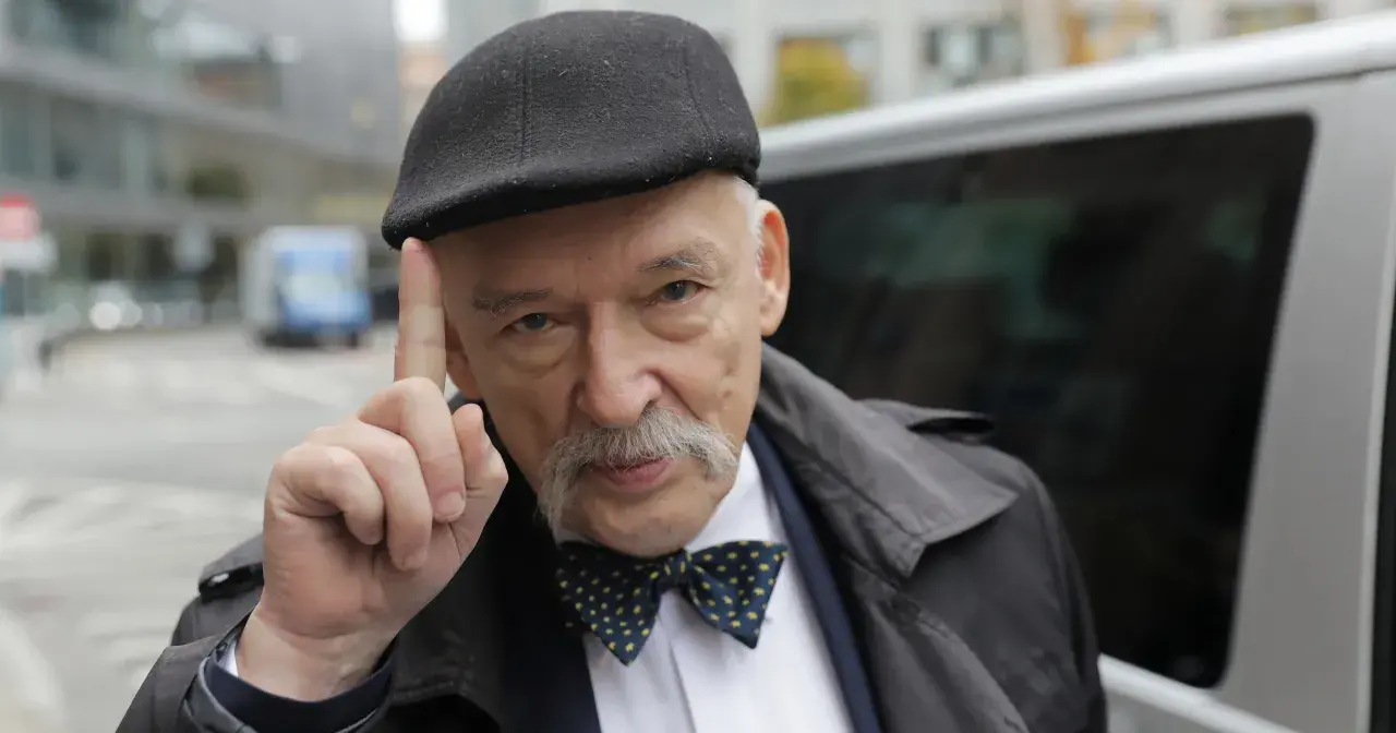 Janusz Korwin-Mikke w czapce i muszce, unoszący palec, budzi spekulacje fanów Konfederacji o jego powrocie.