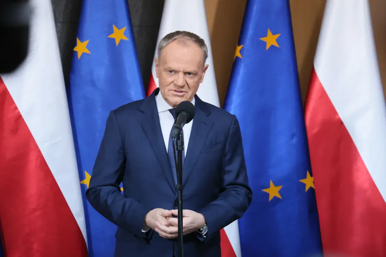 Premier przemawia na tle flag Polski i UE. Sondaże nie dają pewności, czy rząd koalicyjny przetrwa 2026 rok w niezmienionym składzie.
