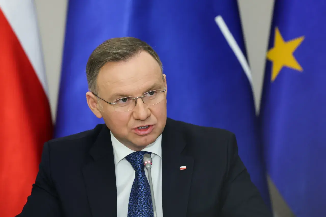 Andrzej Duda w garniturze, za nim flagi Polski i UE. Prawdziwe powody dla których Andrzej Duda zapowiedział serię wet do ustaw budżetowych.