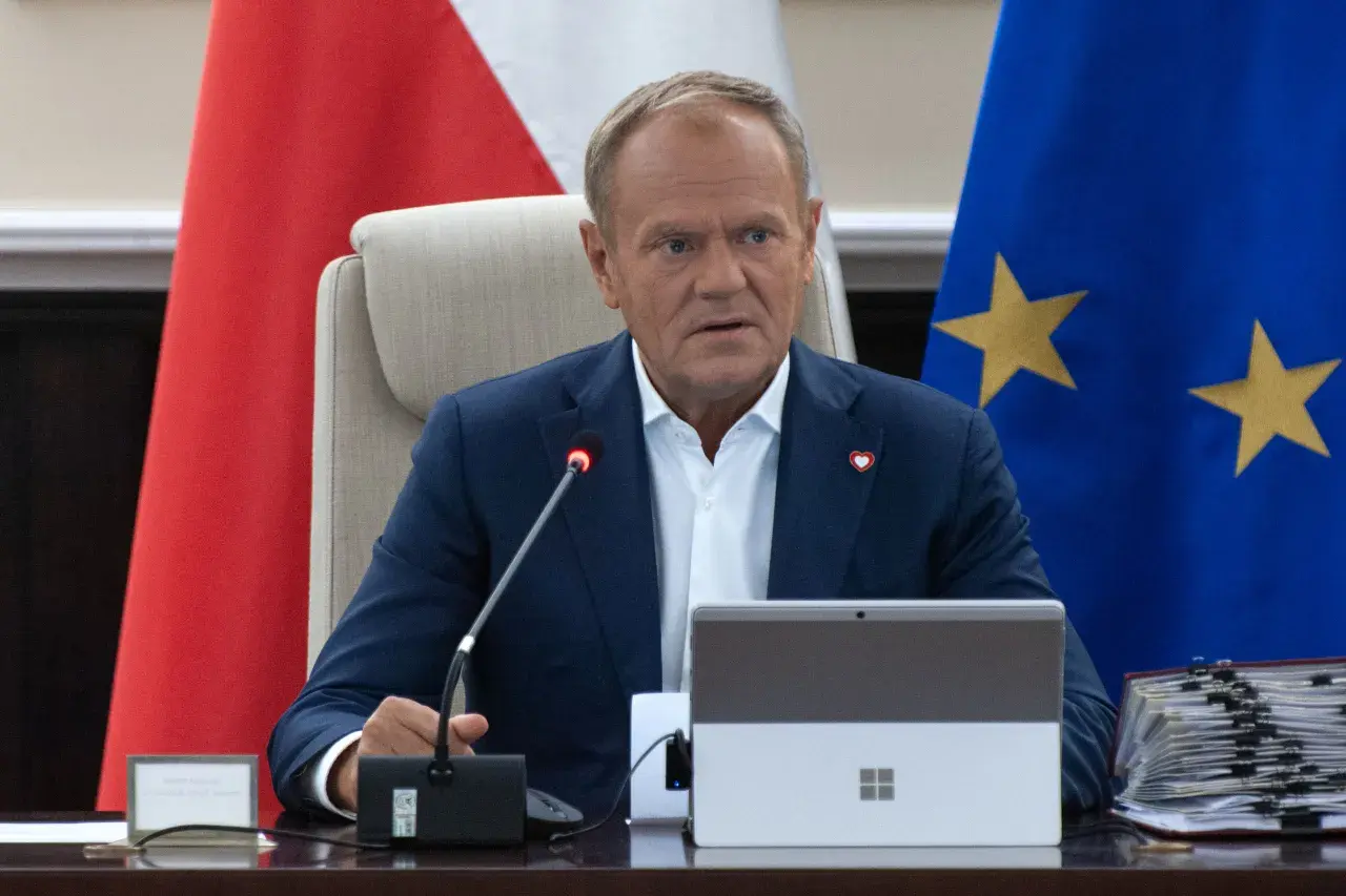 Donald Tusk siedzi przy stole, za nim flagi Polski i UE. Fani Konfederacji zarzucają rządowi "przeklejanie agendy eurokratycznej".