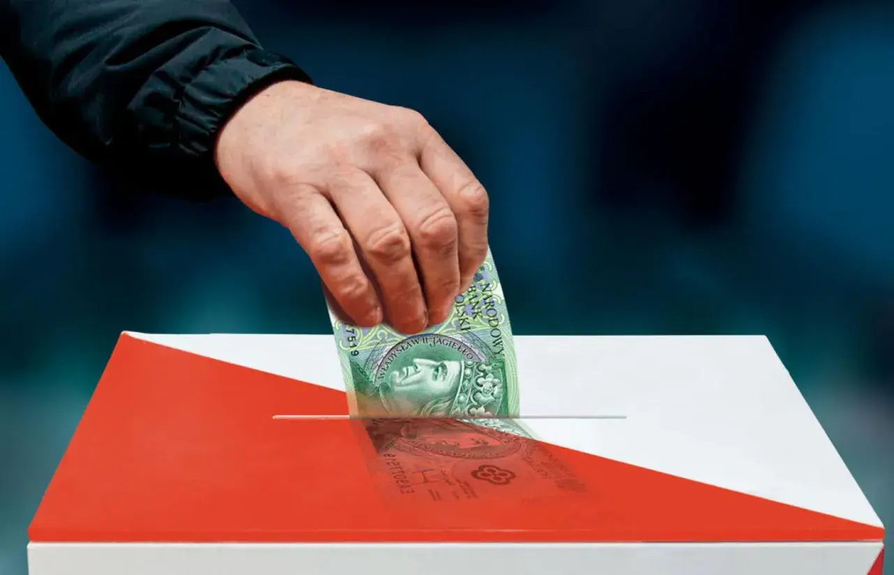 Dłoń wrzuca banknot 100 zł do urny w barwach narodowych.