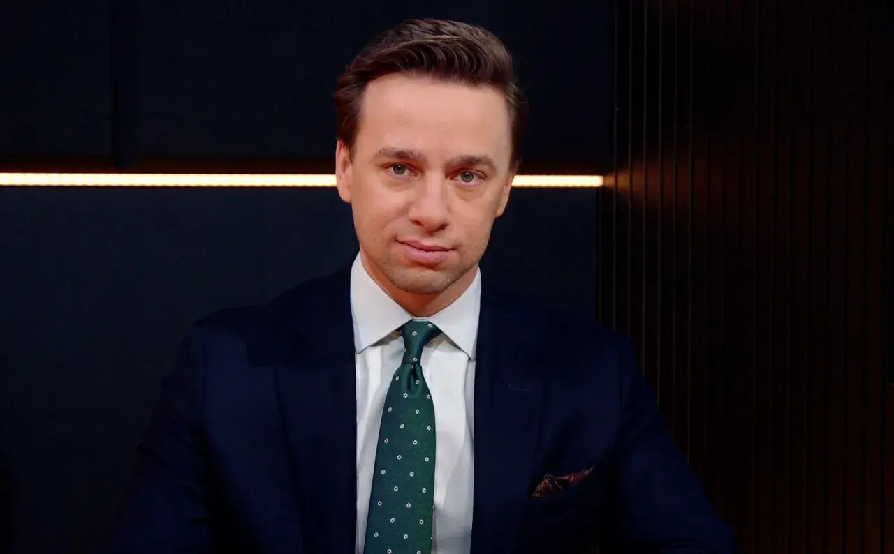 Krzysztof Bosak w garniturze, z zielonym krawatem w kropki. Mówi o tym, dlaczego uważa, że polska polityka zagraniczna nie jest asertywna.