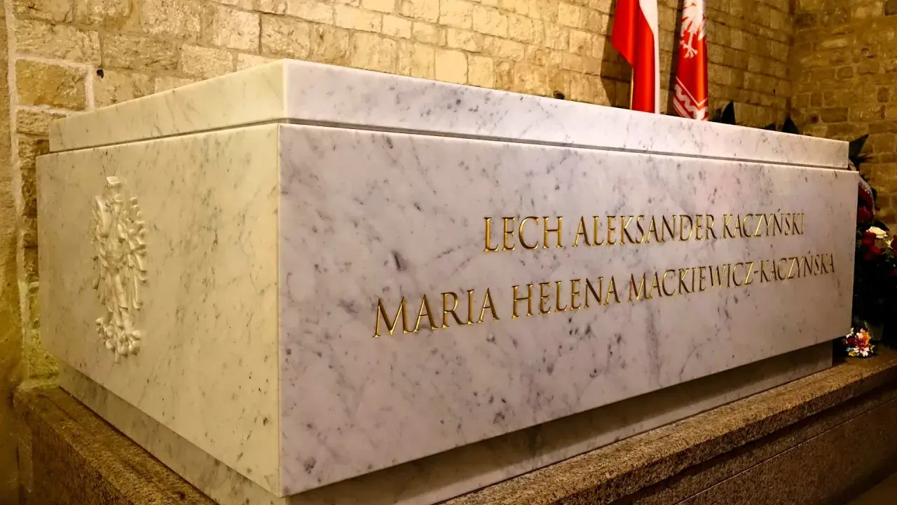 Kamienny grobowiec Lecha i Marii Kaczyńskich na Wawelu. Złote litery wyryte na marmurze.