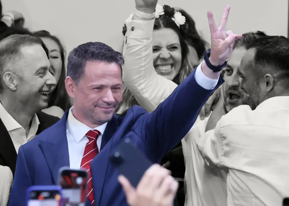 Karol Nawrocki z uśmiechem i gestem zwycięstwa, otoczony entuzjastycznym tłumem. To obraz, który może sugerować, dlaczego Karol Nawrocki wygrywa w najnowszych sondażach prezydenckich z marca 2026.