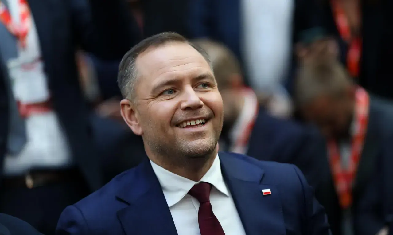 Uśmiechnięty mężczyzna w garniturze z polską flagą na klapie. Czy to jego styl życia wyjaśnia, dlaczego urząd prezydenta jest uznawany za najdroższy w utrzymaniu w całej Europie Środkowej?