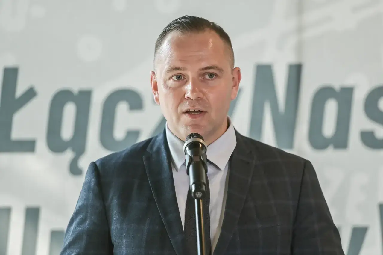 Karol Nawrocki przemawia do mikrofonu. Jego rosnące zaufanie na prawicy może wynikać z jego działań.