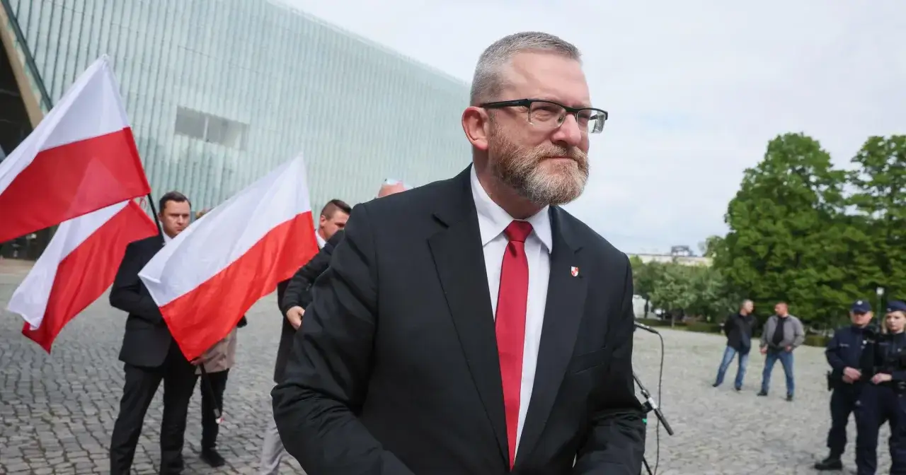 Grzegorz Braun w garniturze i z polską flagą. Czy jego kontrowersyjne wypowiedzi o Izraelu doprowadzą do wykluczenia go z klubu?