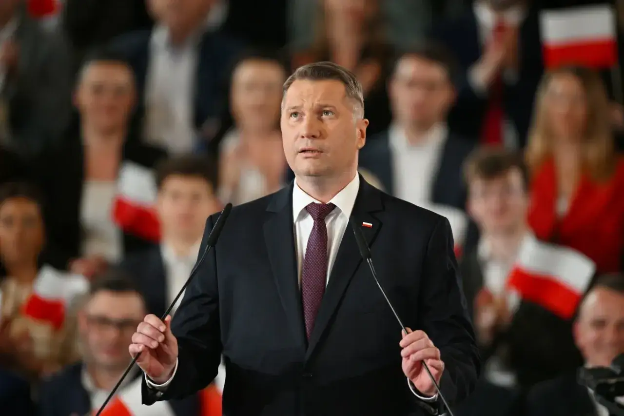 Mężczyzna w garniturze przemawia na tle tłumu z polskimi flagami. Czy to on, kogo Jarosław Kaczyński ogłosi 7 marca jako kandydata na premiera?