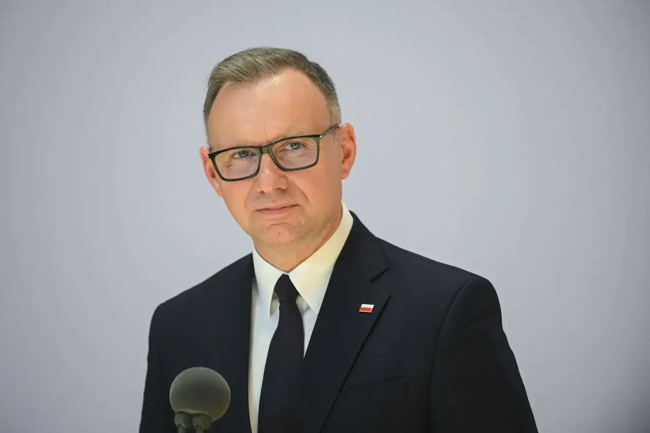 Prezydent Andrzej Duda w garniturze i okularach, z mikrofonem przed sobą. Czy jego oświadczenie majątkowe na koniec dziesięcioletniej służby skrywa sekrety?
