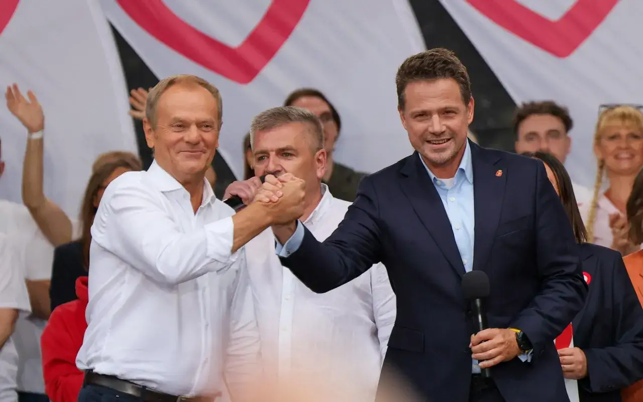 Donald Tusk i Rafał Trzaskowski ściskają sobie dłonie. Czy Donald Tusk rzeczywiście obawia się ambicji prezydenckich Rafała Trzaskowskiego?