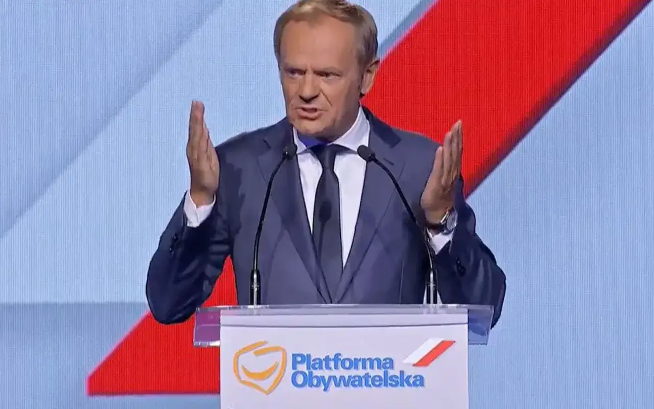 Donald Tusk przemawia na tle logo Platformy Obywatelskiej, gestykulując. Kulisy decyzji o jego jedynej kandydaturze na przewodniczącego partii.